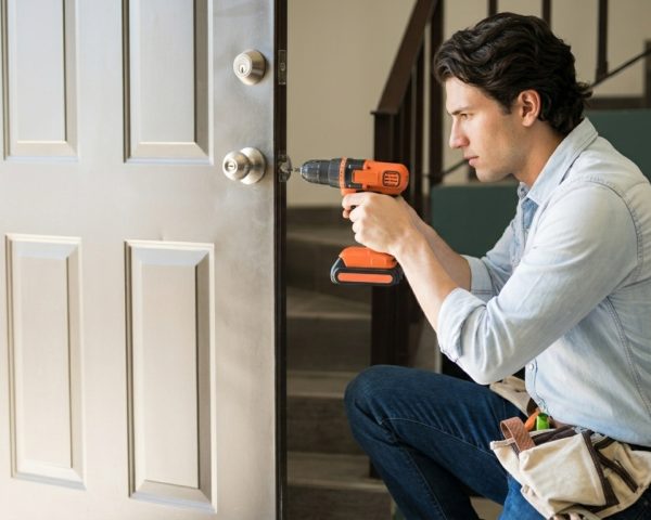 Man_repairing_house_door_